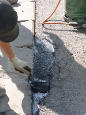 Nid de poule — compactage du matériau de réparation